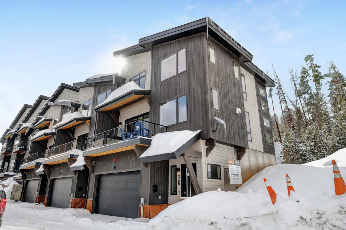 A modern building with balconies set against a snowy landscape, evoking the spirit of mountain adventure. The scene captures the inviting atmosphere of winter sports and après-ski activities, with opportunities to relax on balconies and enjoy the mountain air.